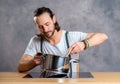 Young bearded man with cooking pot and egg whish