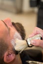 Bearded man getting beard haircut at hairdresser at barbershop