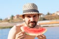 Young bearded man with a watermelon on the beach Royalty Free Stock Photo