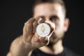 Young bearded man holding virtual currency ethereum coin. Cryptocurrency.