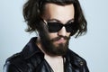 Young bearded man in a leather. Hipster in sunglasses Royalty Free Stock Photo