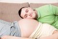 Young bearded man putting his ear close to his pregnant wifes abdomen and Listening it Royalty Free Stock Photo