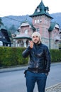 Young bearded man sending kisses on background of Beautiful old pink house in the mountain