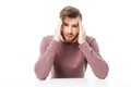 Young man showing headache gesture sitting at the table isolated Royalty Free Stock Photo