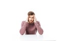 Young man showing headache or thinking gesture sitting at the table isolated Royalty Free Stock Photo