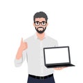 Young bearded man showing laptop and gesturing thumbs up Royalty Free Stock Photo