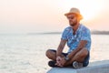 Young man sitting by the sea in sunset Royalty Free Stock Photo