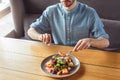 Lunch Time. Guy sitting at table eating salmon salad concentrated close-up Royalty Free Stock Photo