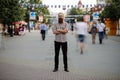 Young bearded man standing still at sidewalk in crowd traffic with people moving around Royalty Free Stock Photo