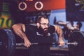 Young bearded man straining to lift heavy weights during a workout session in a gym Royalty Free Stock Photo