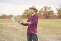 Young bearded man in summer hat lost in the forest and search the road on map f