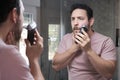 Young bearded man trimming his beard with a trimmer. Royalty Free Stock Photo