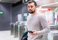 Young man using smartphone to check schedule on subway station Royalty Free Stock Photo