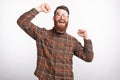 Young bearded man is very happy and makes the winner gesture on white background. Royalty Free Stock Photo