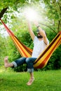 Young bearded man wearing virtual reality goggles relaxing in a garden hammock. Lifestyle VR fun Royalty Free Stock Photo