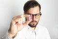 Young Bearded Man Wearing White Shirt Glasses Holding Pink Color Pill.Medicine Health Care People Concept Photo.Adult