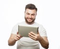 young bearded man wearing white t-shirt using a tablet computer Royalty Free Stock Photo