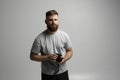 Young bearded proffesional photographer man with a dslr camera over white background.