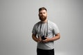 Young bearded proffesional photographer man with a dslr camera over white background.