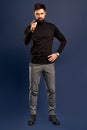 Young bearded stylish teacher or business man pointing finger at camera. Full body length portrait isolated on Pacific Blue studio Royalty Free Stock Photo