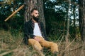 Young bearded tourist in the woods resting under a tree on an autumn day Royalty Free Stock Photo