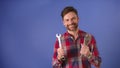 Young bearded unconfident man holding tools and smiles . Isolated