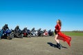 Young beatiful woman posing in front of seven bikers.