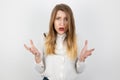 Young beatuiful blond angry woman looks desperate standing on isolated white background, splash of emotions