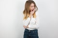 Young beatuiful blond woman looks tired yawning on isolated white background, body language Royalty Free Stock Photo