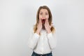 Young beatuiful blond woman standing on isolated white background looks surprised, pure beauty concept