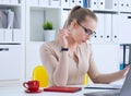 Young beauiful Caucasian businesswoman in glasses working on notebook computer and business document at office.