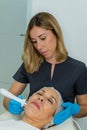 esthetician performs relaxing treatment on the cheekbone of a woman