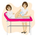 Young beautician waxing young woman legs lying on spa bed Royalty Free Stock Photo