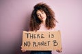 Young beautiful activist woman with curly hair and piercing protesting asking for change planet with a confident expression on