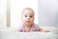 Young beautiful, adorable girl lying on a bed with white background. Parent and child are laughing and playing together. Cute baby