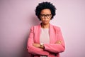 Young beautiful African American afro businesswoman with curly hair wearing pink jacket skeptic and nervous, disapproving Royalty Free Stock Photo