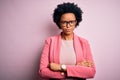 Young beautiful African American afro businesswoman with curly hair wearing pink jacket skeptic and nervous, frowning upset Royalty Free Stock Photo