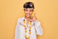 Young beautiful african american afro hippie woman wearing sunglasses and accessories smiling doing phone gesture with hand and Royalty Free Stock Photo