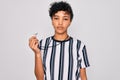 Young beautiful african american afro referee woman wearing striped uniform using whistle with a confident expression on smart