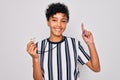 Young beautiful african american afro referee woman wearing striped uniform using whistle surprised with an idea or question