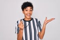 Young beautiful african american afro referee woman wearing striped uniform using whistle very happy and excited, winner