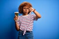 Young beautiful African American afro woman with curly hair on vacation drinking glass of beer with angry face, negative sign Royalty Free Stock Photo