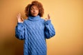 Young beautiful African American afro woman with curly hair wearing blue turtleneck sweater relax and smiling with eyes closed Royalty Free Stock Photo