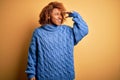Young beautiful African American afro woman with curly hair wearing blue turtleneck sweater very happy and smiling looking far Royalty Free Stock Photo