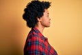 Young beautiful African American afro woman with curly hair wearing casual shirt looking to side, relax profile pose with natural Royalty Free Stock Photo