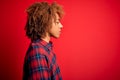 Young beautiful African American afro woman with curly hair wearing casual shirt looking to side, relax profile pose with natural Royalty Free Stock Photo