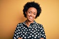 Young beautiful African American afro woman with curly hair wearing casual shirt standing happy face smiling with crossed arms Royalty Free Stock Photo