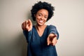 Young beautiful African American afro woman with curly hair wearing casual sweater pointing to you and the camera with fingers, Royalty Free Stock Photo