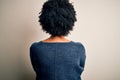 Young beautiful African American afro woman with curly hair wearing casual sweater standing backwards looking away with crossed Royalty Free Stock Photo