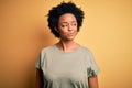 Young beautiful African American afro woman with curly hair wearing casual t-shirt smiling looking to the side and staring away Royalty Free Stock Photo